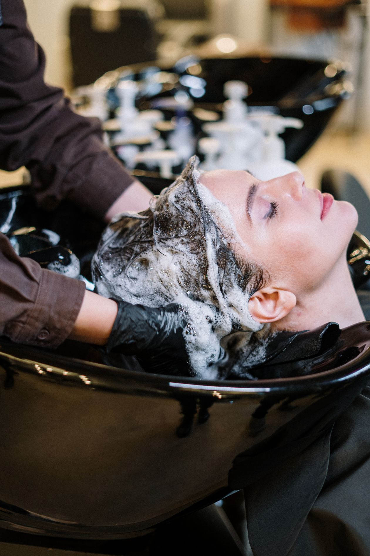 Mulher lavando o cabelo com sabão de coco natural no chuveiro