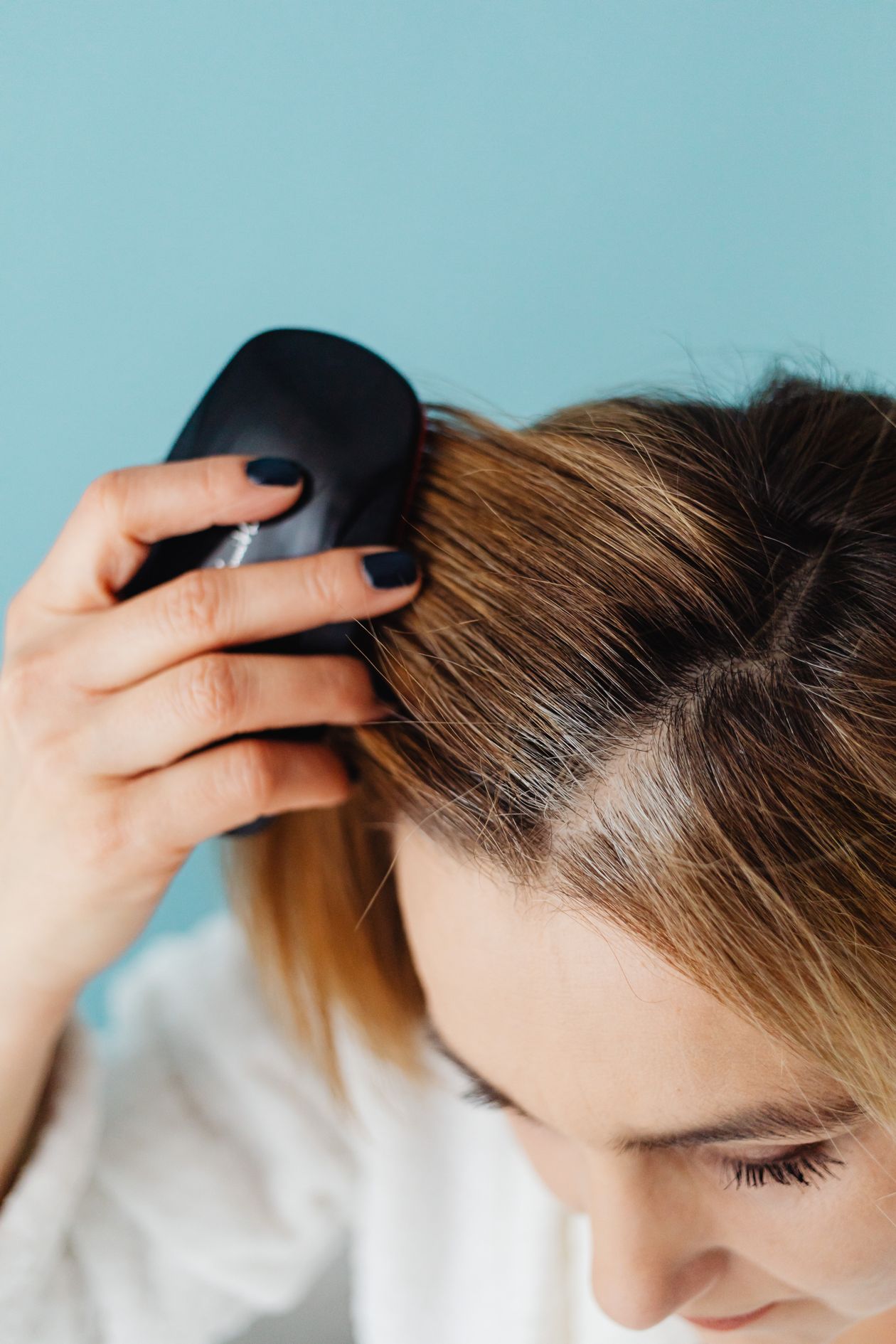 Mulher escovando o cabelo seco, contexto de melhor shampoo Pantene para cabelos secos