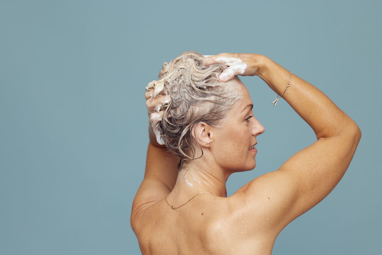 Pessoa lavando o cabelo com shampoo, contexto de shampoo para cabelo ressecado infantil