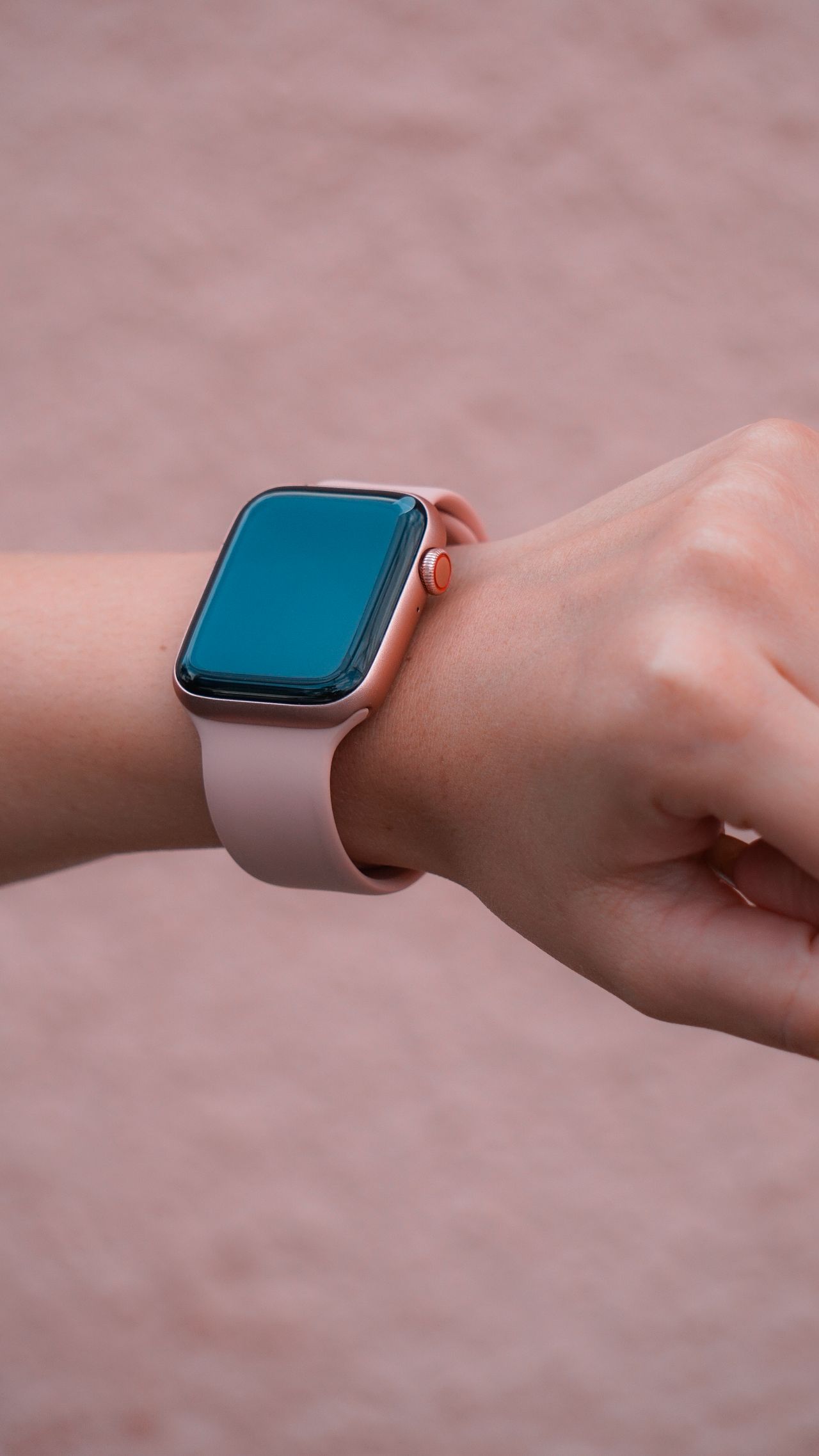 Close-up de relógio inteligente rosa no pulso feminino, contexto de smartwatch barato e acessível