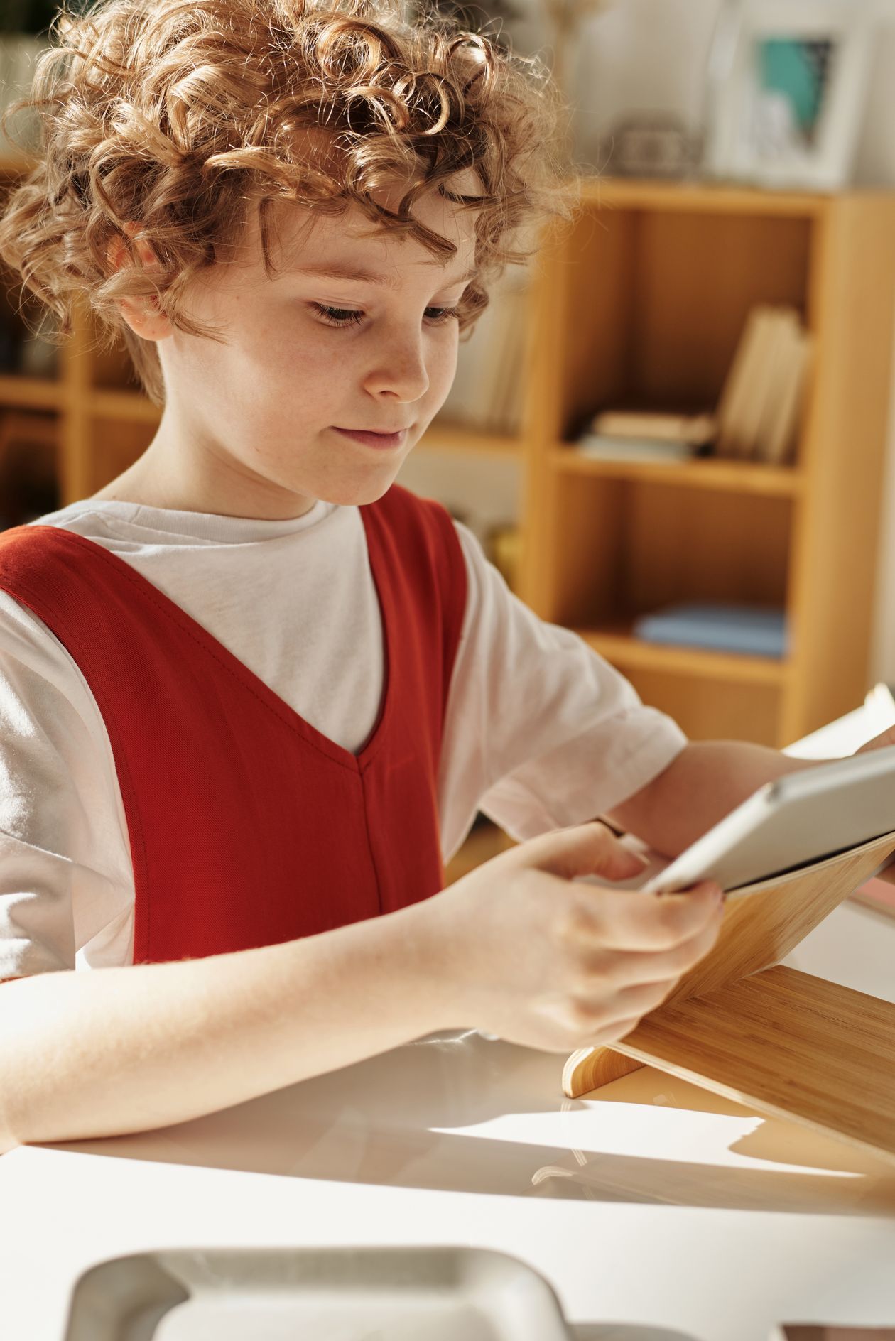 Criança usando tablet para aprender em casa, contexto de melhor tablet infantil Positivo ou Multilaser