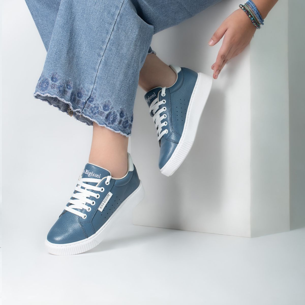 Tênis casual feminino de couro combinado com jeans, contexto de slip on e look urbano