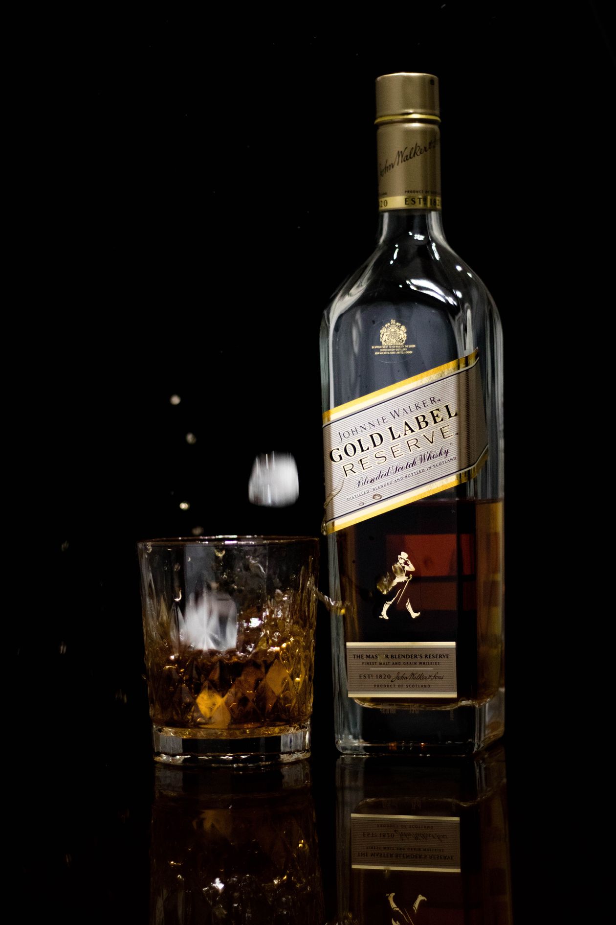 Copo de whisky puro ao lado da garrafa
